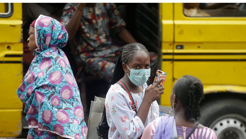 A woman wearing a face mask walks nearby the Central Mosque in Lagos, Nigeria, Friday, March 20, 2020. The government banned all religious activities for four weeks following confirmation of coronavirus cases in the country.  Sunday Alamba/AP Photo