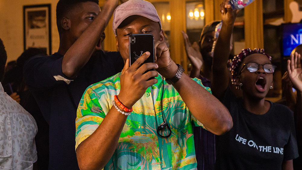 A man films with his mobile phone during the Life on the Line Concert. Photo Credit: Tonton Raymond﻿